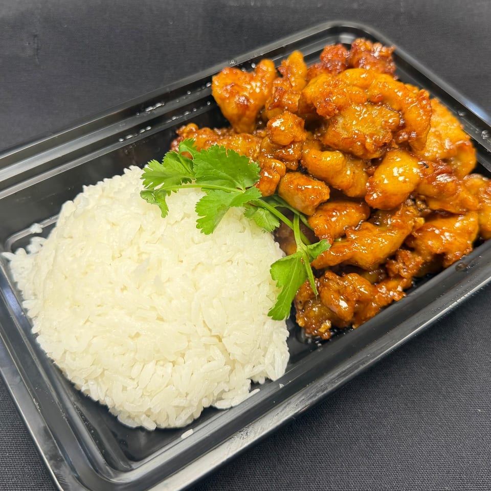 Tuk Tuk Express's orange chicken with white rice and cilantro in a black takeout container.